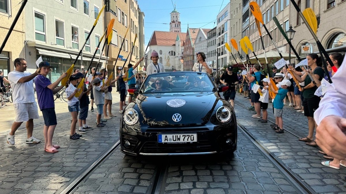 Die erfolgreichen Wildwasser-Kanuten Noah Hegge und Elena Lilik beim Autokorso durch die Augsburger Innenstadt.