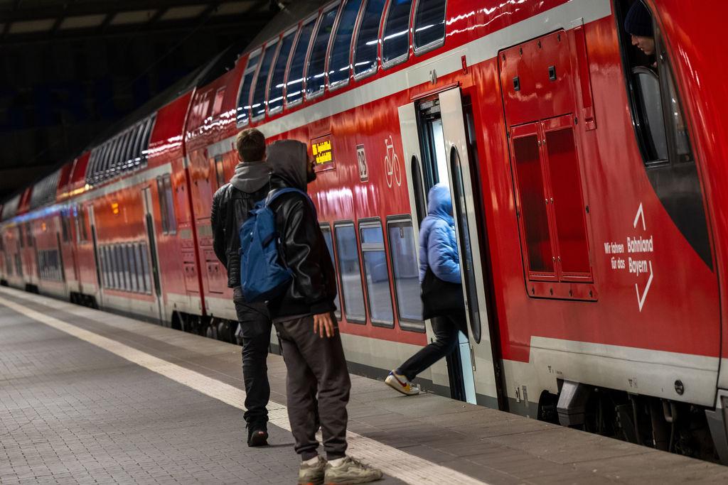 ARCHIV - 27.03.2023, Bayern, München: Reisende im Hauptbahnhof München vor einer Regionalbahn. (zu dpa: «Bahn-Fahrplanwechsel: Flughafenexpress nach Nürnberg») Foto: Peter Kneffel/dpa +++ dpa-Bildfunk +++