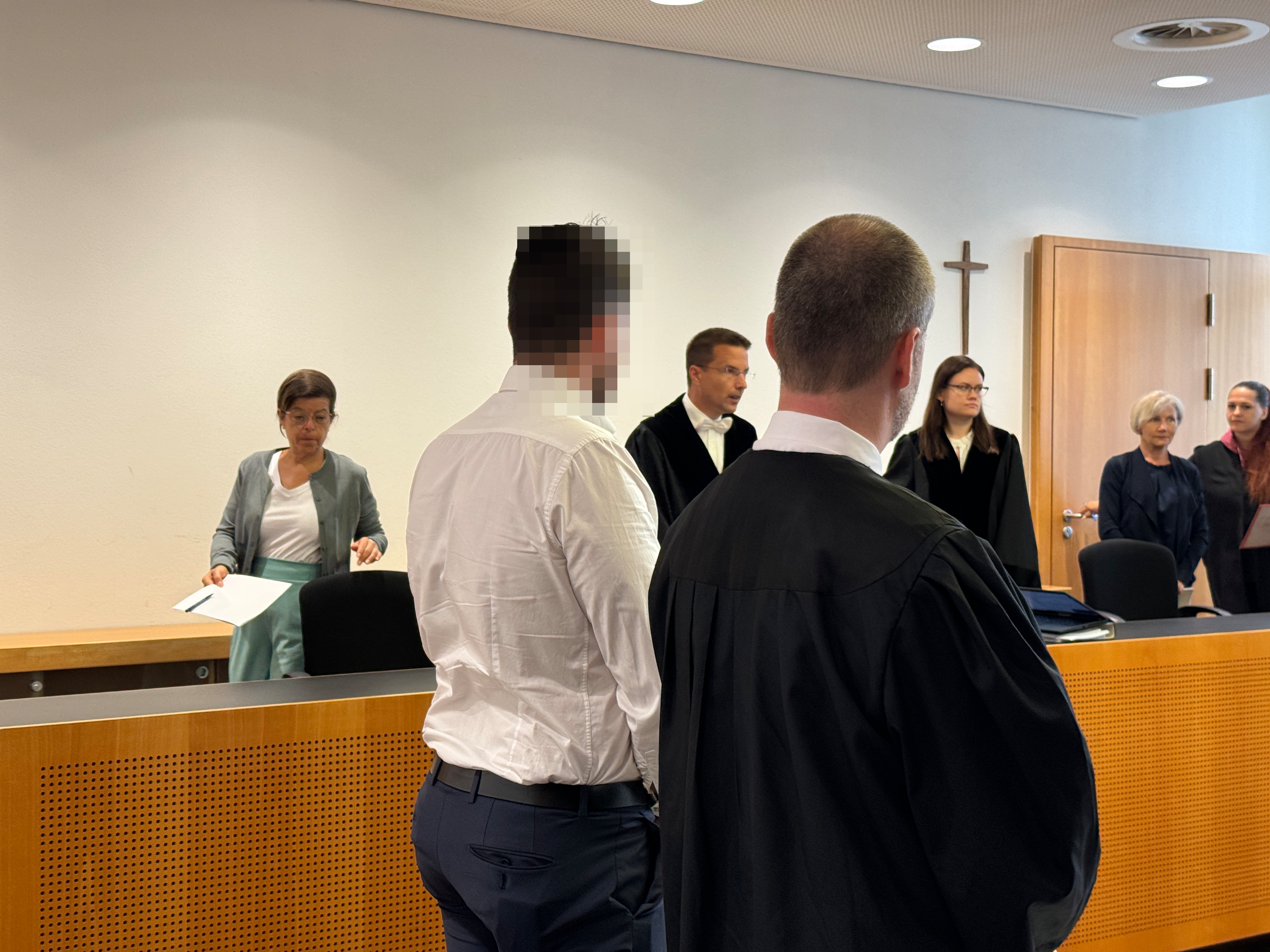 Der angeklagte Polizist steht in weißem Hemd neben seinem Verteidiger vor dem Landgericht Augsburg