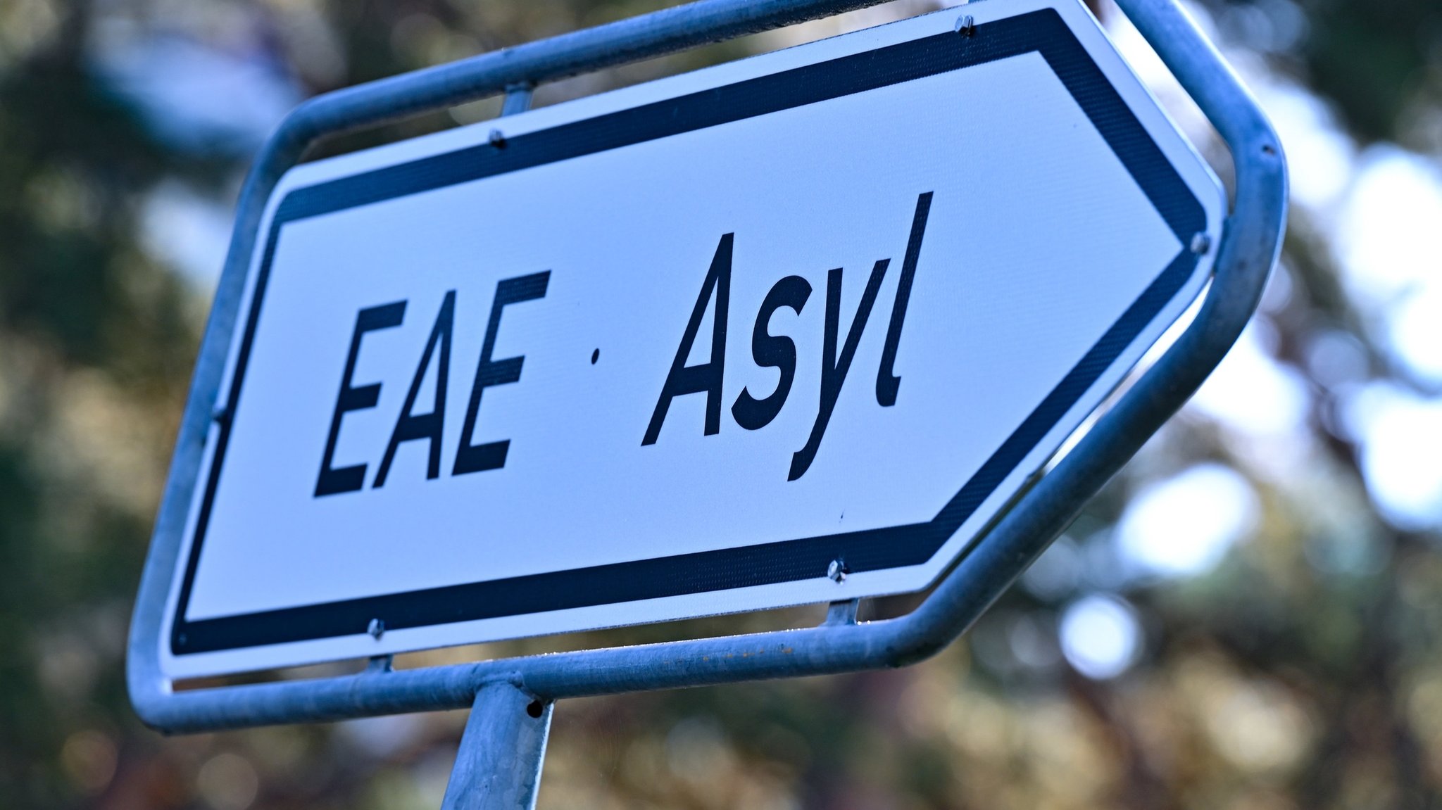 ARCHIV - 06.09.2023, Brandenburg, Eisenhüttenstadt: Ein Wegweiser mit der Abkürzung «EAE» und «Asyl» zur Erstaufnahme-Einrichtungen (EAE) des Landes Brandenburg in Eisenhüttenstadt. (Illustration zu dpa: "Gemeindebund zweifelt an schnellerem Asylverfahren und Bezahlkarte") Foto: Patrick Pleul/dpa +++ dpa-Bildfunk +++