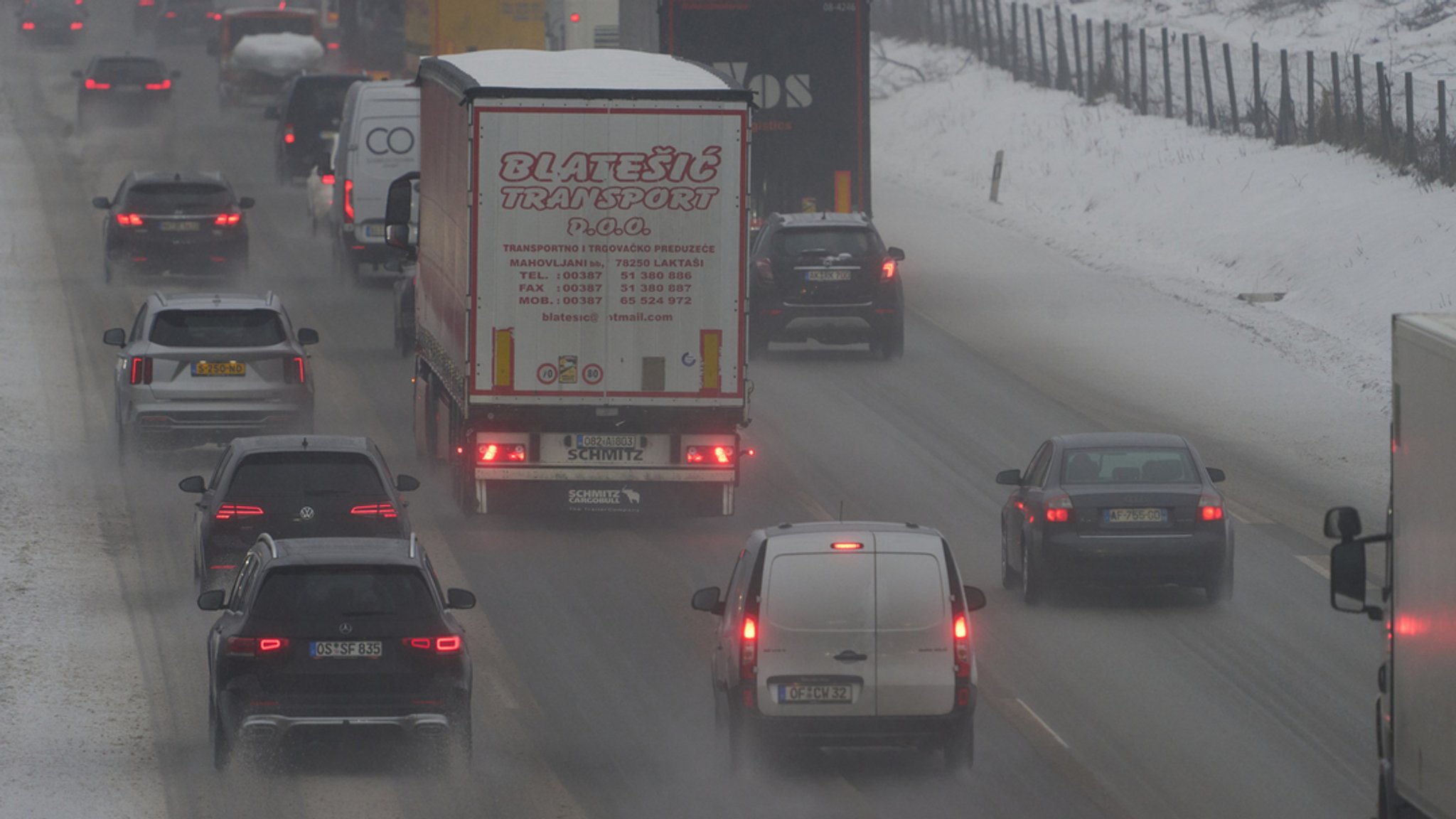 PKW und Lastwagen auf einer Autobahn.