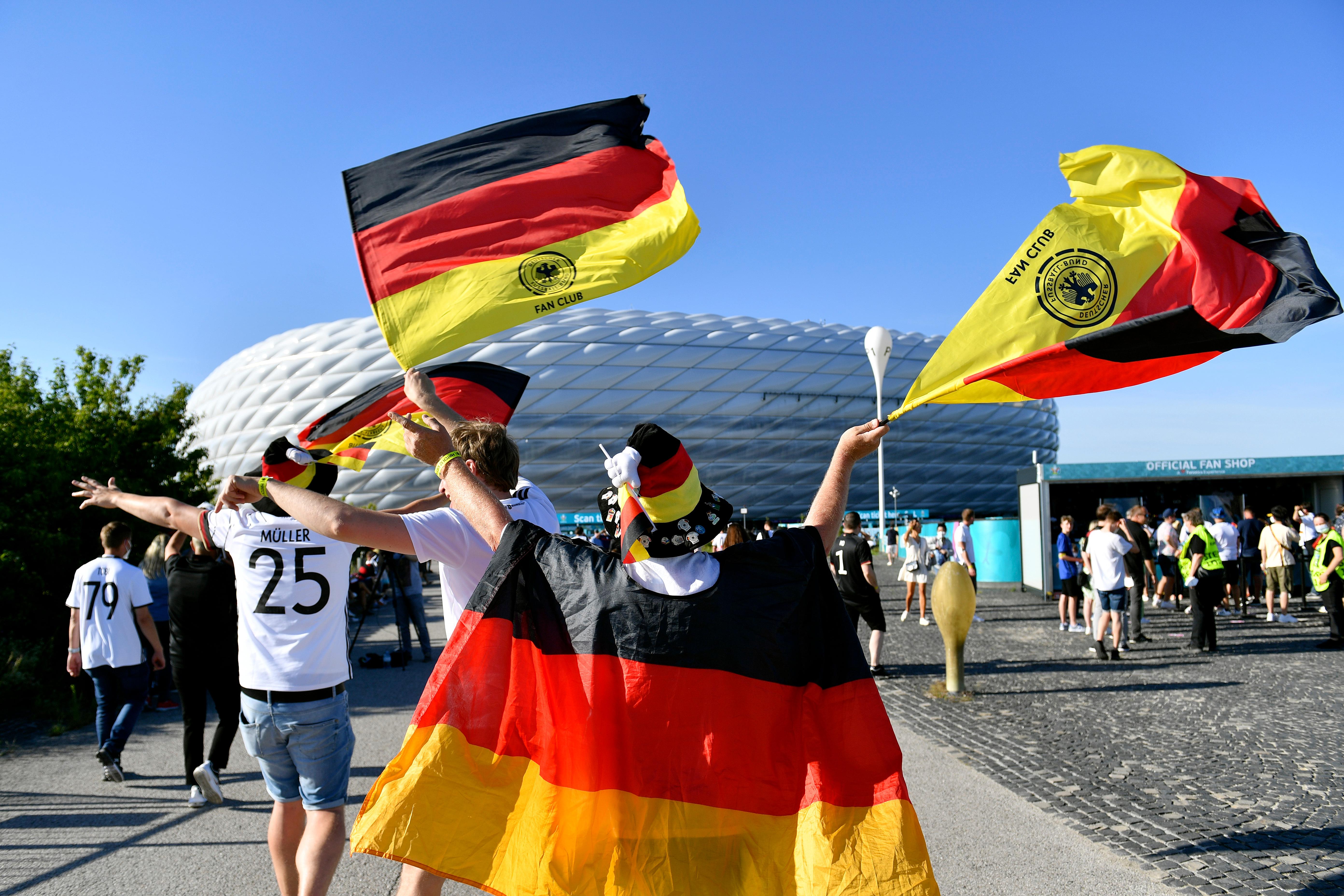 Ein Fußball-Fan mit Deutschland-Flaggen vor dem Münchner Fußball-Stadion