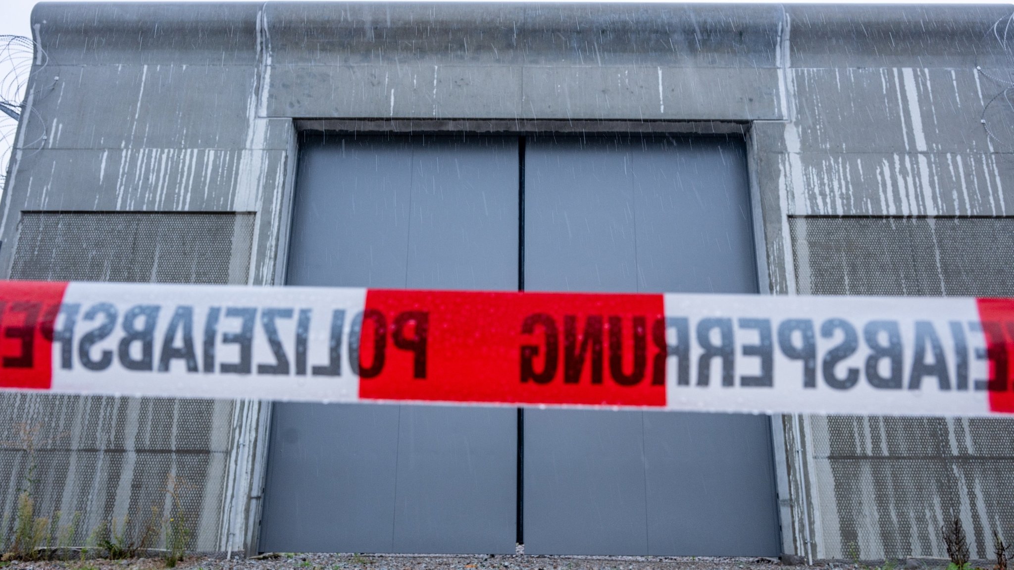 18.08.2024, Bayern, Straubing: Ein Absperrband der Polizei ist vor einem Tor des Bezirkskrankenhauses Straubing angebracht. Vier Männer sind am Samstagabend im niederbayerischen Straubing aus der geschlossenen Klinik entflohen. Laut Polizei laufen umfangreiche Fahndungsmaßnahmen. Foto: Armin Weigel/dpa +++ dpa-Bildfunk +++