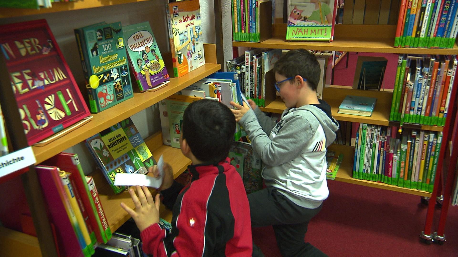 Kinder suchen versteckte Kastanien in einem Bücherregal