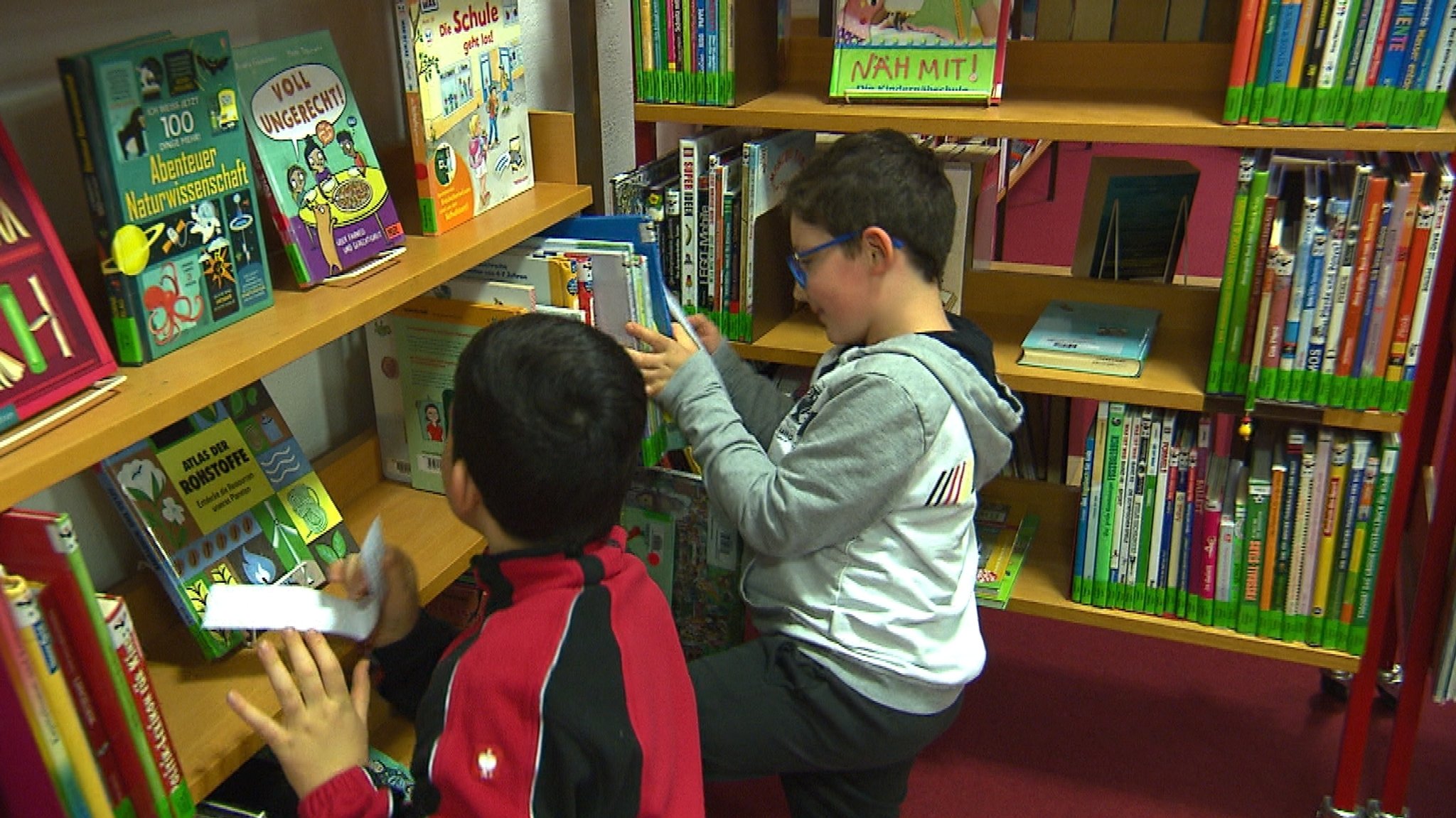 Kinder suchen versteckte Kastanien in einem Bücherregal