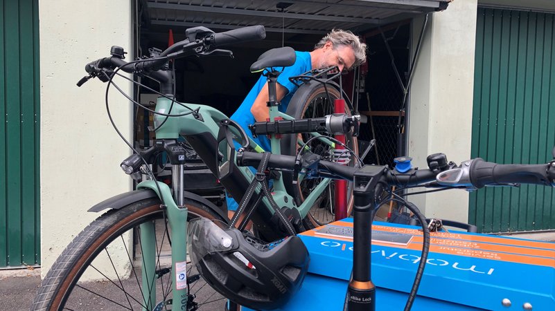 Stefan Dietrich repariert das Fahrrad einer Kundin.