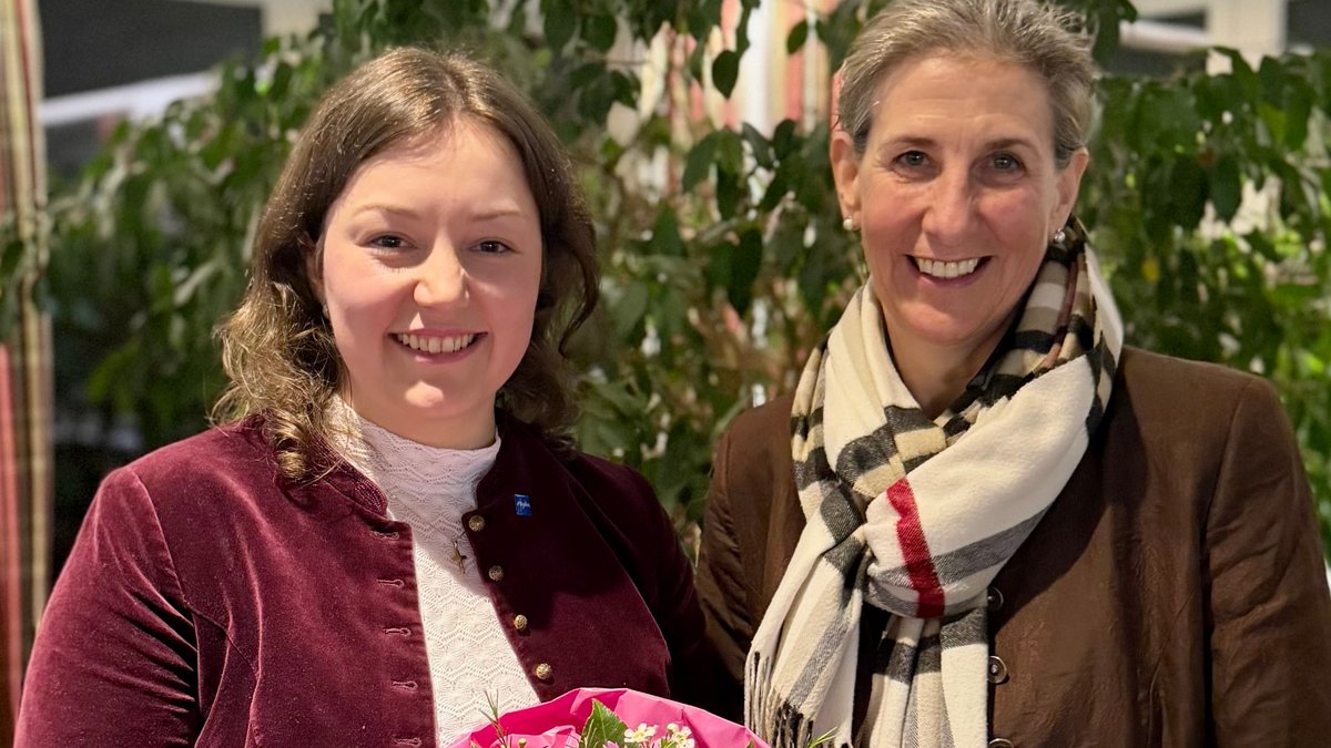 Die 27-jährige Philine Blees (links) lächelt mit Blumen in die Kamera. Sie wurde als neue Bürgermeisterin von Obermaiselstein gewählt.