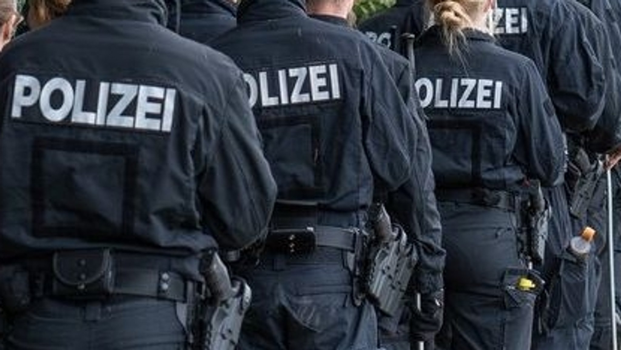 Mehrere Polizisten gehen hintereinander.