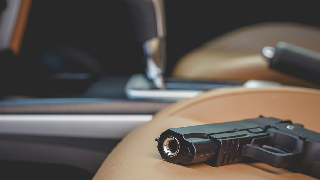 Eine Pistole liegt auf dem Sitz eines Autos. 