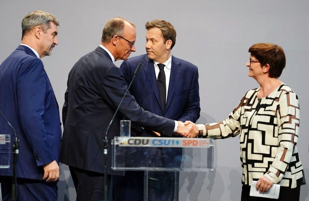 09.04.2025, Berlin: Friedrich Merz (2.v.l), Unions-Kanzlerkandidat und CDU-Bundesvorsitzender, und Saskia Esken (r), SPD-Bundesvorsitzende, geben sich neben Markus Söder (l), Ministerpräsident von Bayern und CSU-Vorsitzender, und Lars Klingbeil, SPD-Fraktions- und Bundesvorsitzender, nach einer Pressekonferenz der Parteivorsitzenden von Union und SPD zur Vorstellung des Koalitionsvertrages im Paul-Löbe-Haus die Hand.