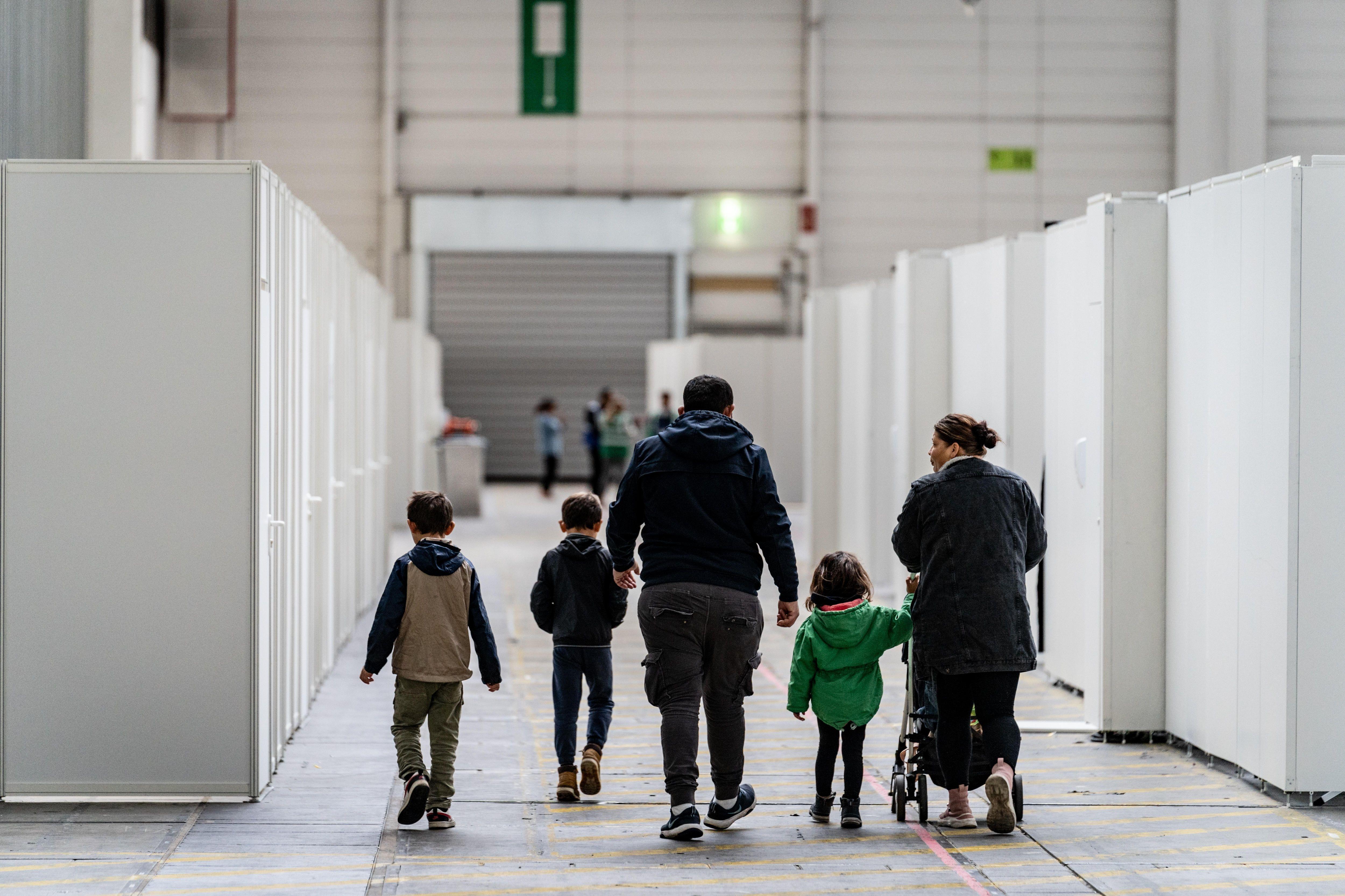 Eine Familie zwischen den für Familien abgeteilten Bereichen einer Flüchtlingsunterkunft in Frankfurt.