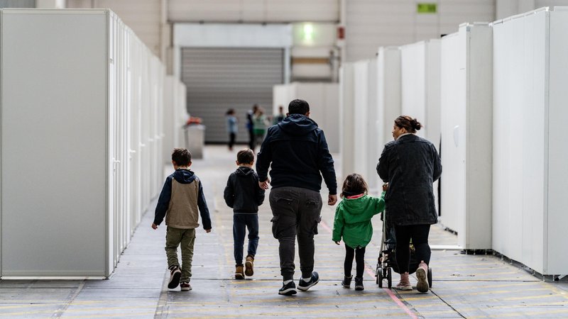 Eine Familie zwischen den für Familien abgeteilten Bereichen einer Flüchtlingsunterkunft in Frankfurt. | Bild: picture alliance / epd-bild | Peter Juelich Eine Familie zwischen den für Familien abgeteilten Bereichen einer Flüchtlingsunterkunft in Frankfurt.