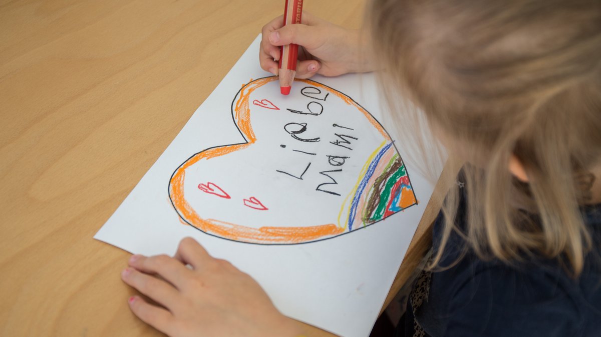 Archivbild: Kind malt Herz zum Muttertag mit bunten Farben