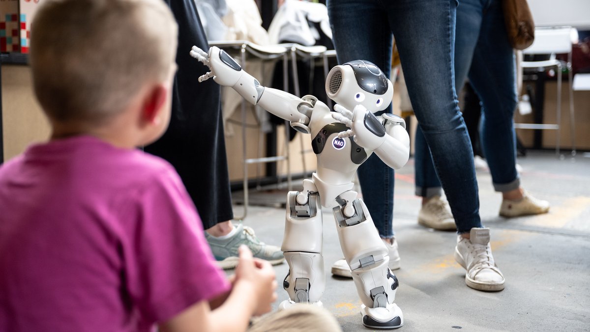 Ein junger Gast der re:publica begegnet einem Roboter