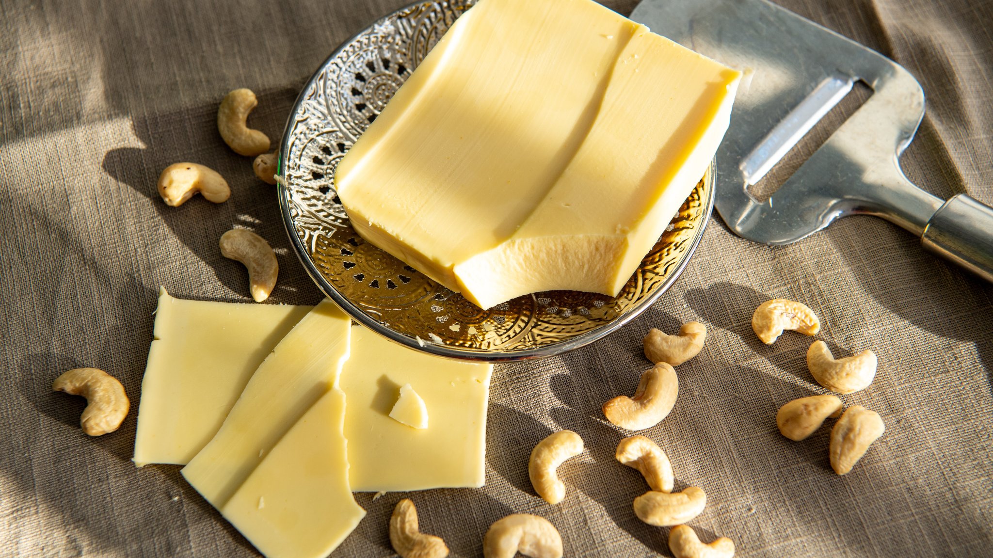 Veganer Käse auf einem Teller und Cashewnüsse 