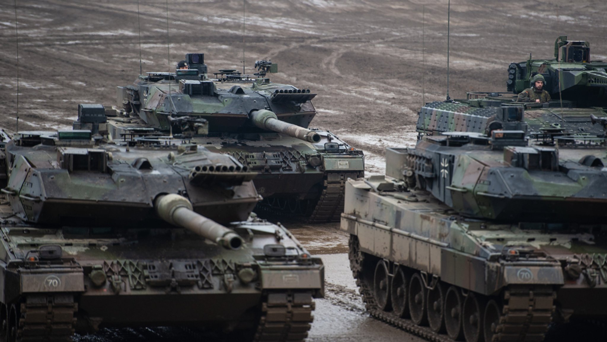 Drei Bundeswehrpanzer rollen über ein schlammiges Feld. (Symbolbild) Die Bundeswehr braucht Gerät und Ausrüstung - Komponenten dafür könnten von früheren Auto-Zulieferern kommen.