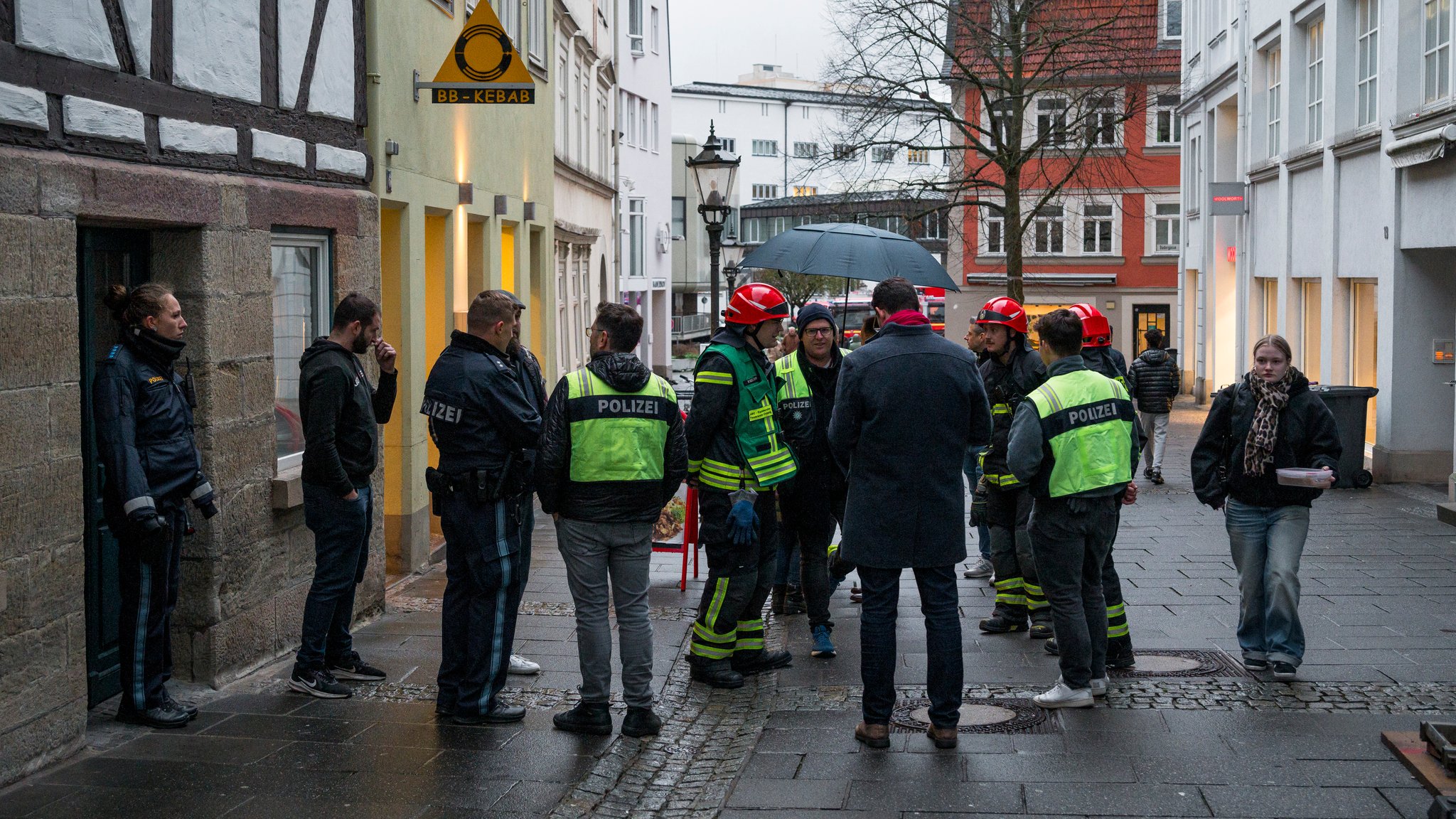 Einsatzkräfte der Polizei und der Feuerwehr stehen nach einem Gasaustritt in der Coburger Innenstadt (03.12.2024)