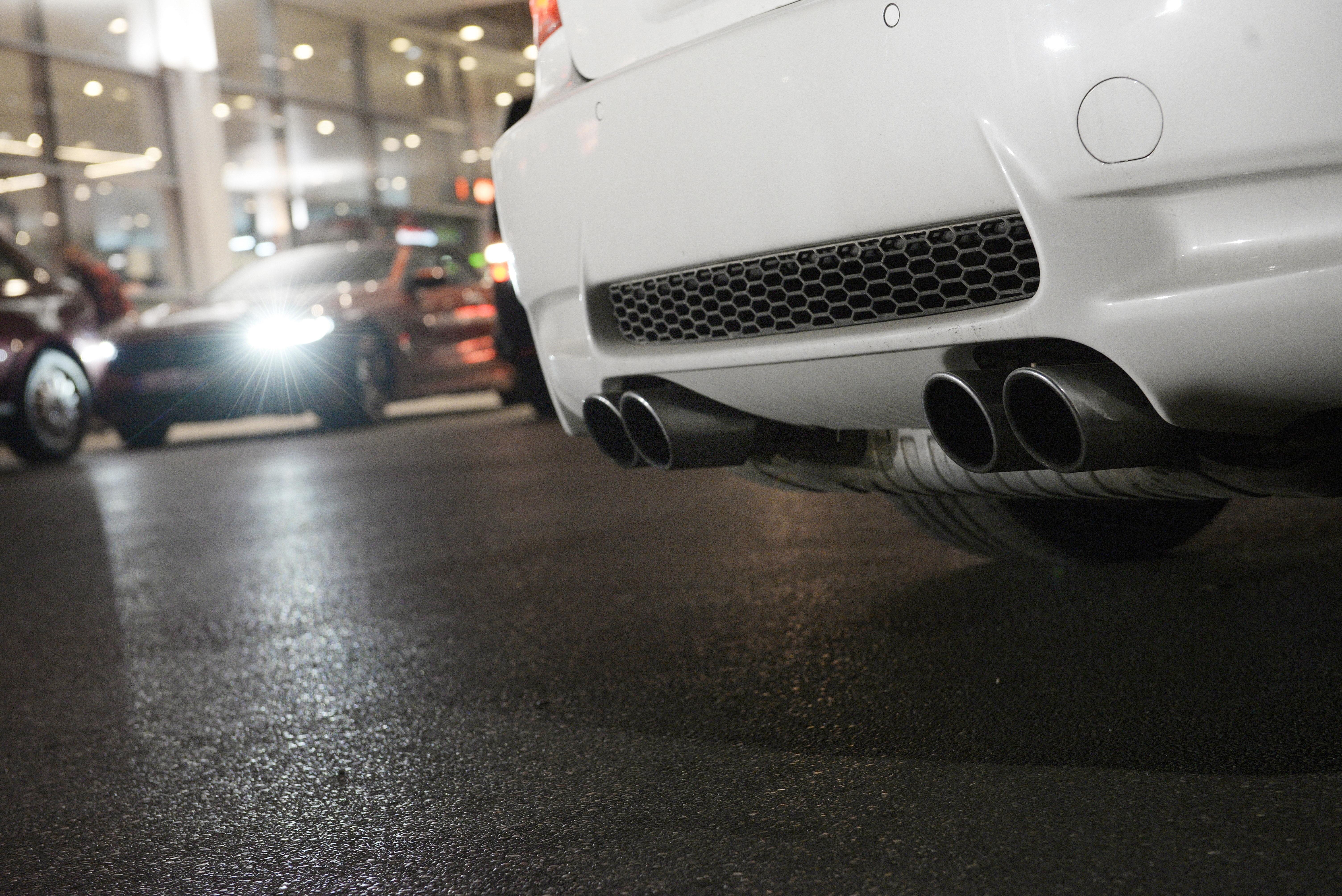 Detailaufnahme eines weißen Autohecks mit vier Auspuffrohren