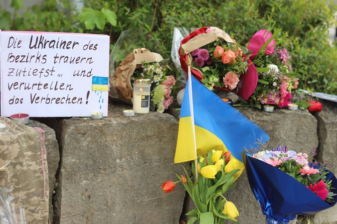28.04.2024, Bayern, Murnau: Am Gelände eines Einkaufszentrums, an dem am Samstagabend (27.04.2024) zwei Männer aus der Ukraine getötet worden sind, wurden Blumen niedergelegt, sowie eine kleine ukrainische Flagge aufgestellt. Die Polizei konnte einen Mann festnehmen, der als dringend tatverdächtig gilt. Es handelt sich dabei um einen 57 Jahre alten Russen. Foto: Constanze Wilz/dpa +++ dpa-Bildfunk +++