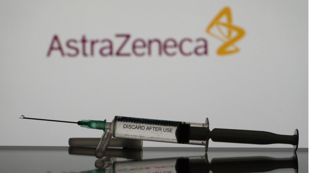 Eine Spritze mit dem Logo von Astrazeneca im Hintergrund (Symbolbild)