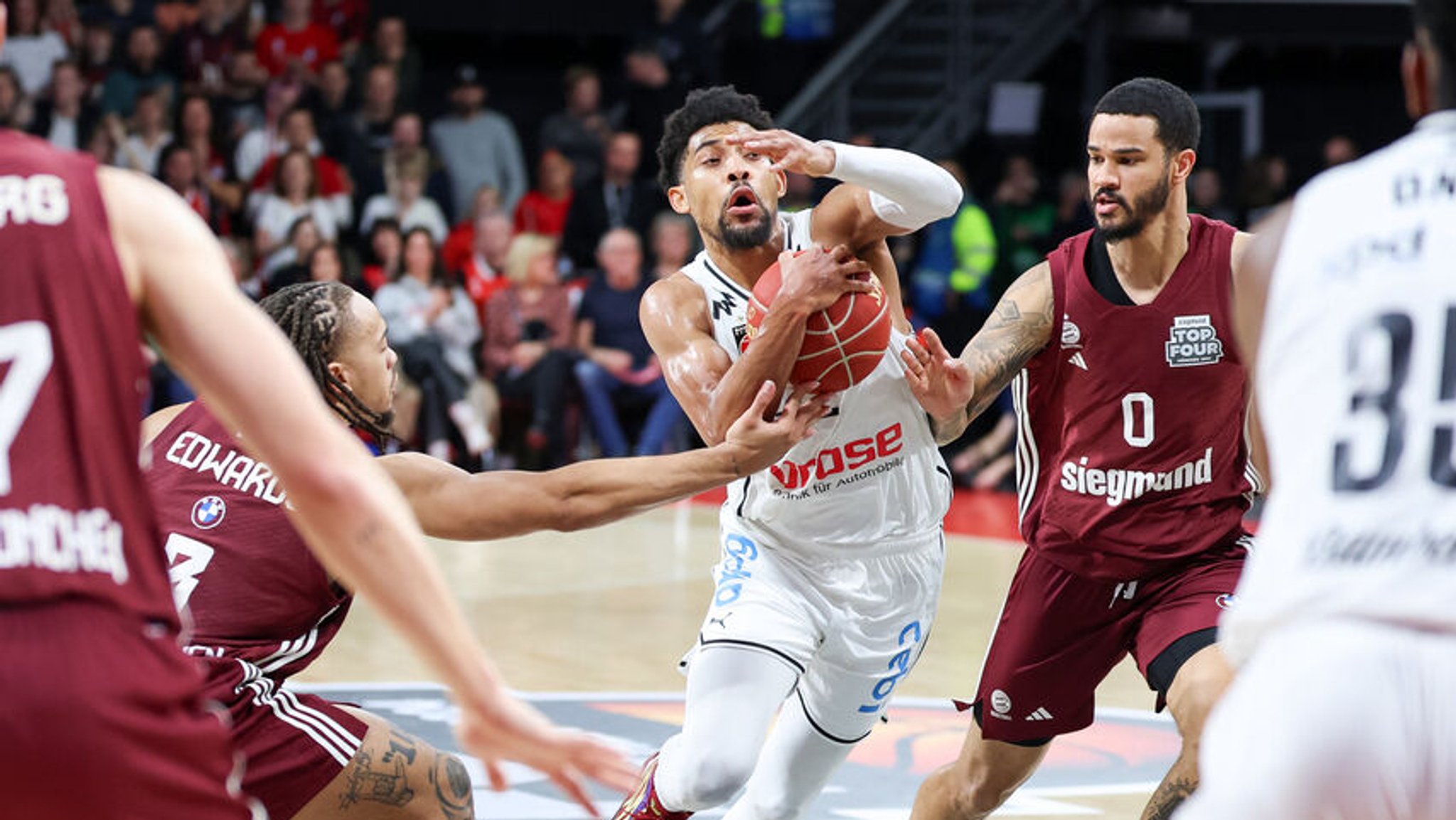 17.02.2024, Bayern, München: Basketball: BBL-Pokal, Brose Bamberg - FC Bayern München, Final Four, Halbfinale, BMW Park. Der Bamberger Zach Copeland (M) geht durch die Münchener Carsen Edwards (l) und Nick Weiler-Babb (r) hindurch. Foto: Daniel Löb/dpa +++ dpa-Bildfunk +++