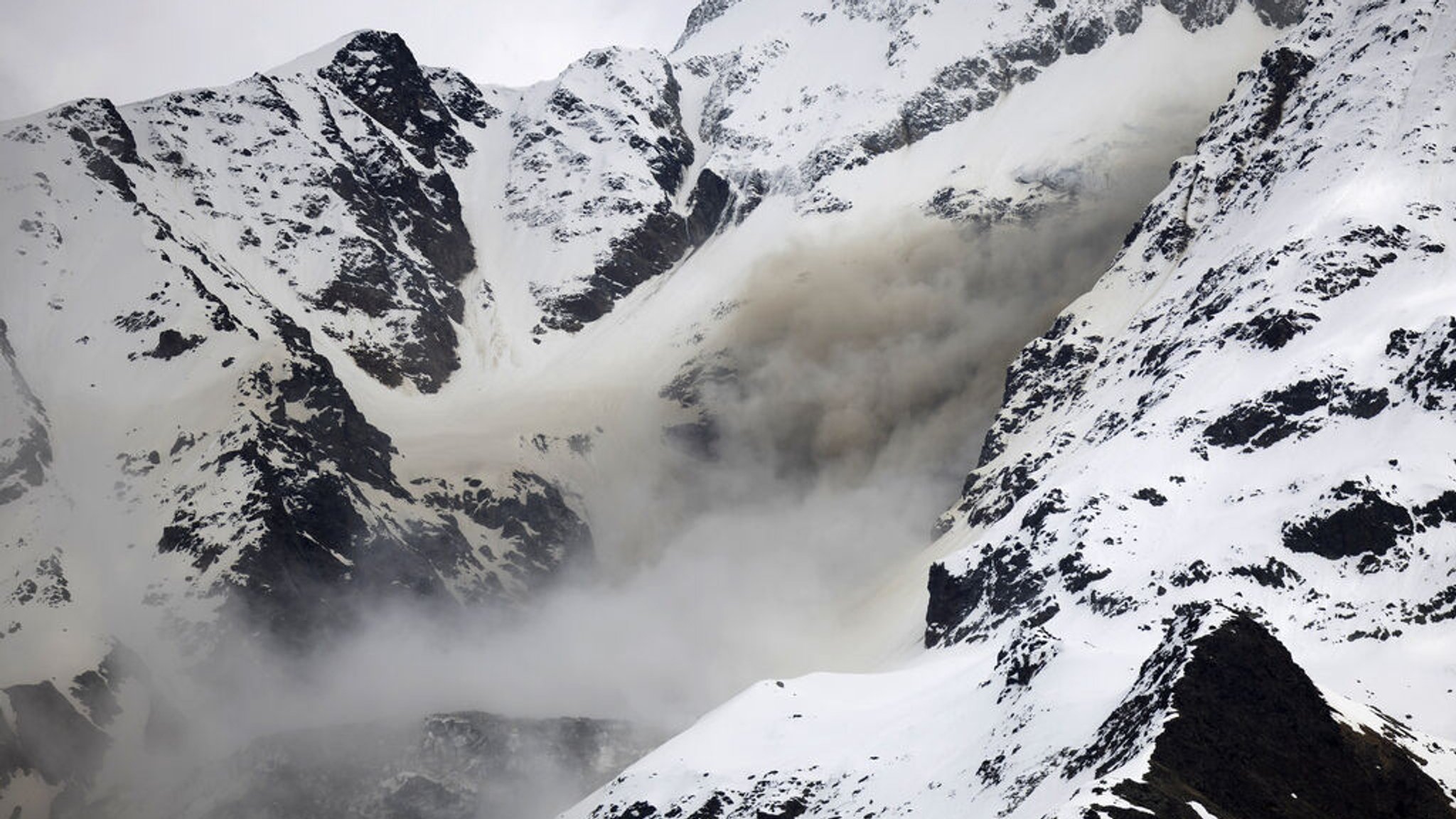 19.05.2025, Schweiz, Blatten: Staub von einem Felssturz steigt auf, an einer Flanke des Berges Bietschhorn im Lötschental, aufgenommen von der Ortschaft Wiler. 