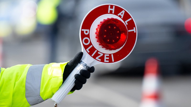 Archivbild vom 06.02.2025: Eine Polizistin kontrolliert in Oberaudorf an einer mobilen Kontrollstelle kurz hinter der Grenze Fahrzeuge, die aus Österreich nach Deutschland kommen, und hält dabei eine Polizeikelle mit der Aufschrift "Halt Polizei" in der Hand. | Bild: dpa-Bildfunk/Sven Hoppe Archivbild vom 06.02.2025: Eine Polizistin kontrolliert in Oberaudorf an einer mobilen Kontrollstelle kurz hinter der Grenze Fahrzeuge, die aus Österreich nach Deutschland kommen, und hält dabei eine Polizeikelle mit der Aufschrift "Halt Polizei" in der Hand.