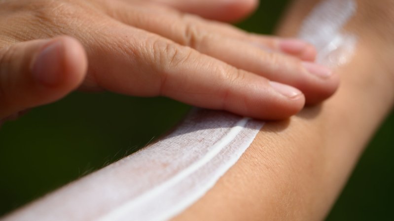 Eine Frau schmiert sich ihren Unterarm mit Sonnencreme ein (Symbolbild)