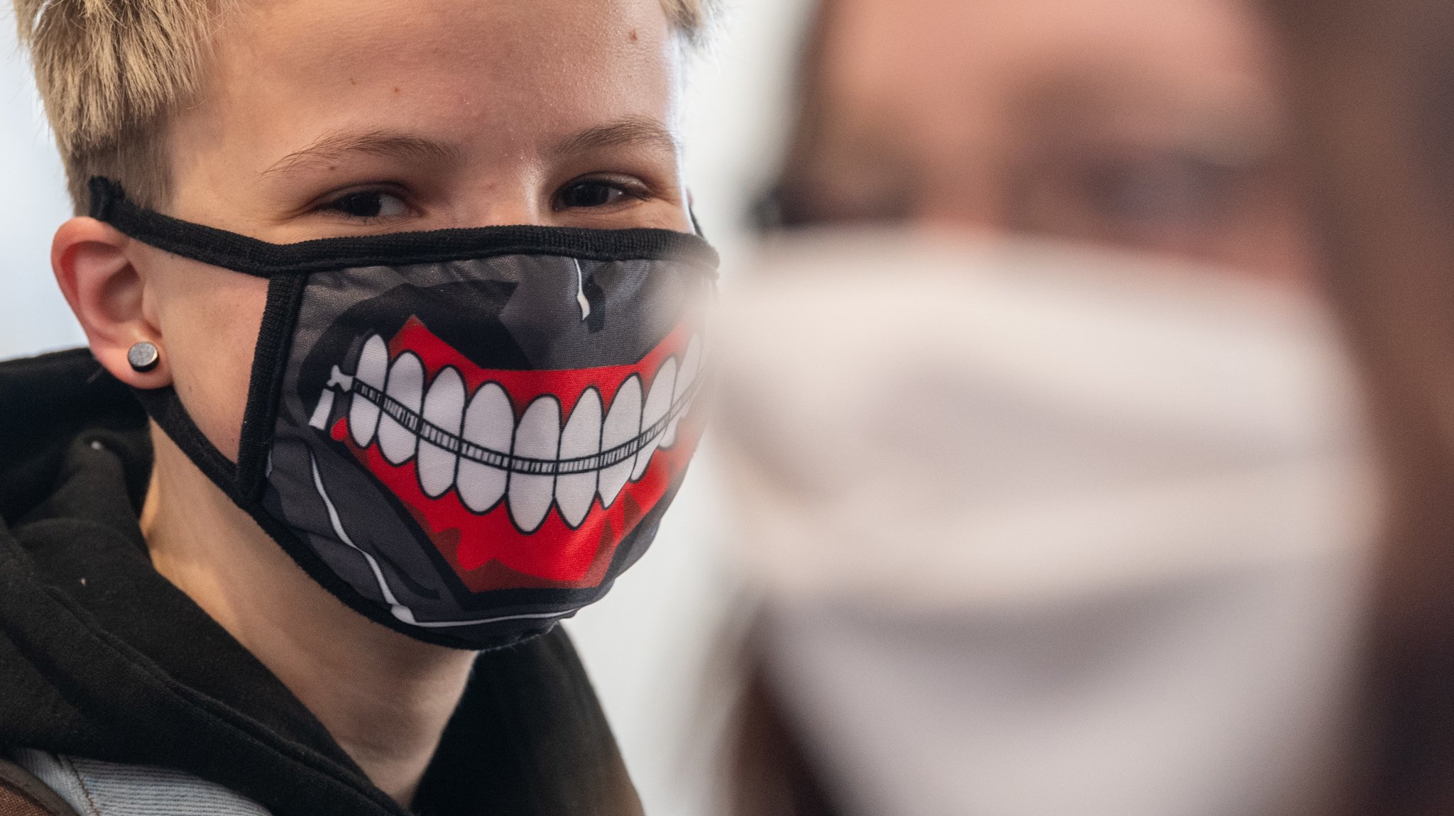 Abiturienten am Gymnasium Dresden Klotzsche stehen vor Beginn der Konsultationen im Treppenhaus und tragen einen Mundschutz. 