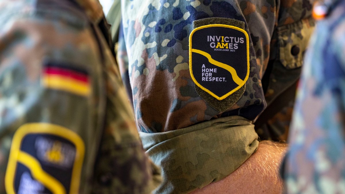 Soldaten der Bundeswehr tragen Badges mit dem Logo der Invictus Games an ihren Tarnfleck-Feldanzügen. Marcel Bohnert, der stellvertretende Vorsitzende des Deutschen Bundeswehrverbandes, erhofft sich von dem Wettkampf mehr Sichtbarkeit für Einsatzveteranen. 