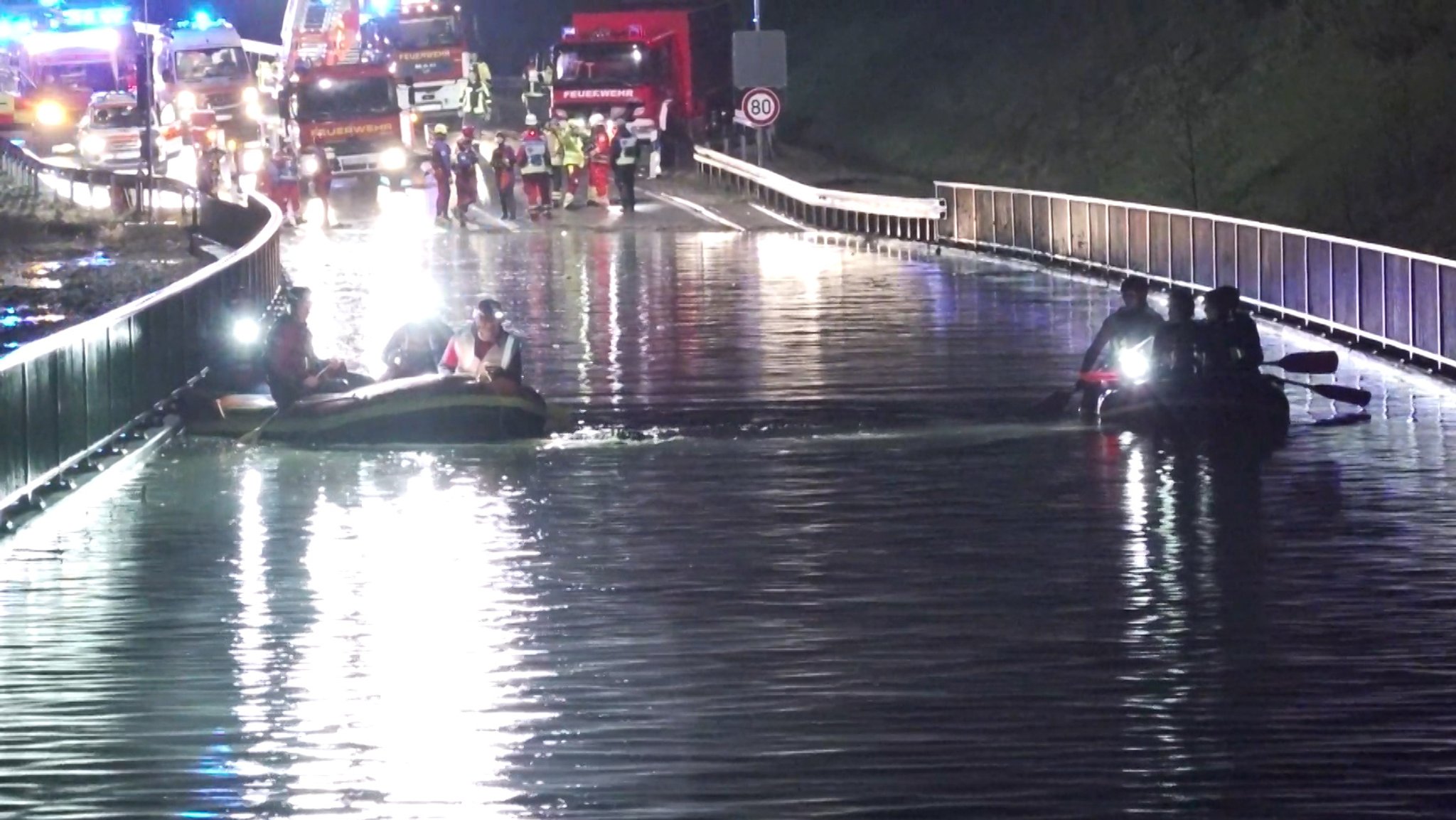 Starkregen hat eine Straße überschwemmt. Rettungskräfte sind mit Booten im Einsatz.