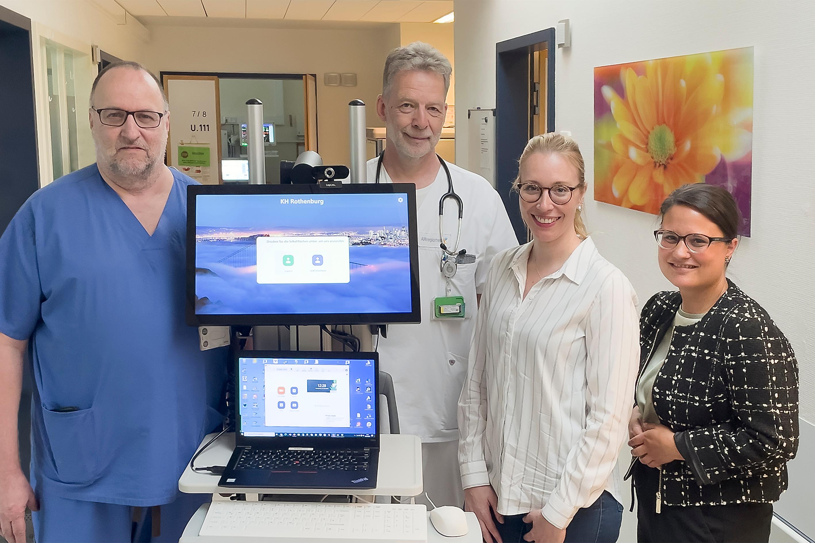 Vier Menschen stehen neben einem mobilen Visitenwagen.