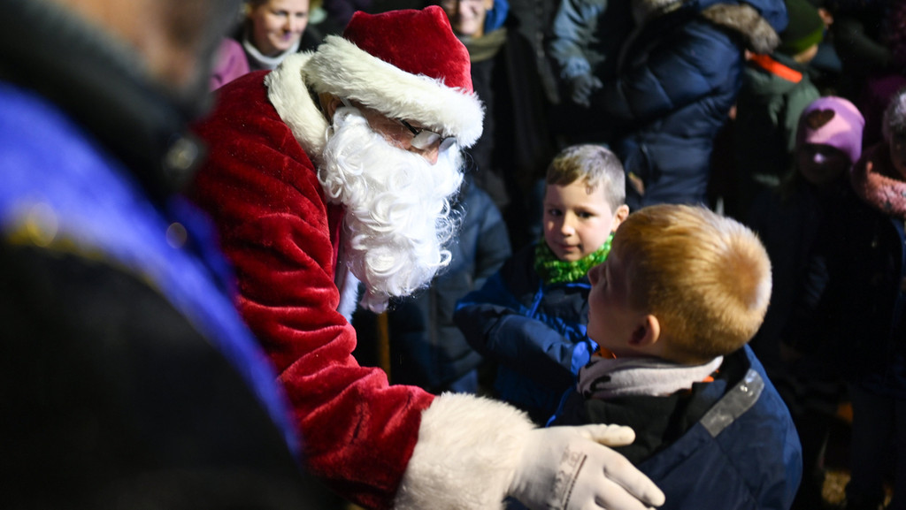 Ein Nikolaus inmitten einer Schar von Kindern.