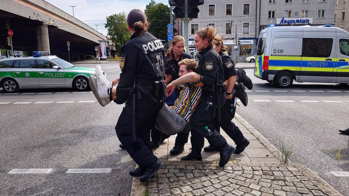 Polizisten tragen in München einen Klimaaktivisten von der Straße