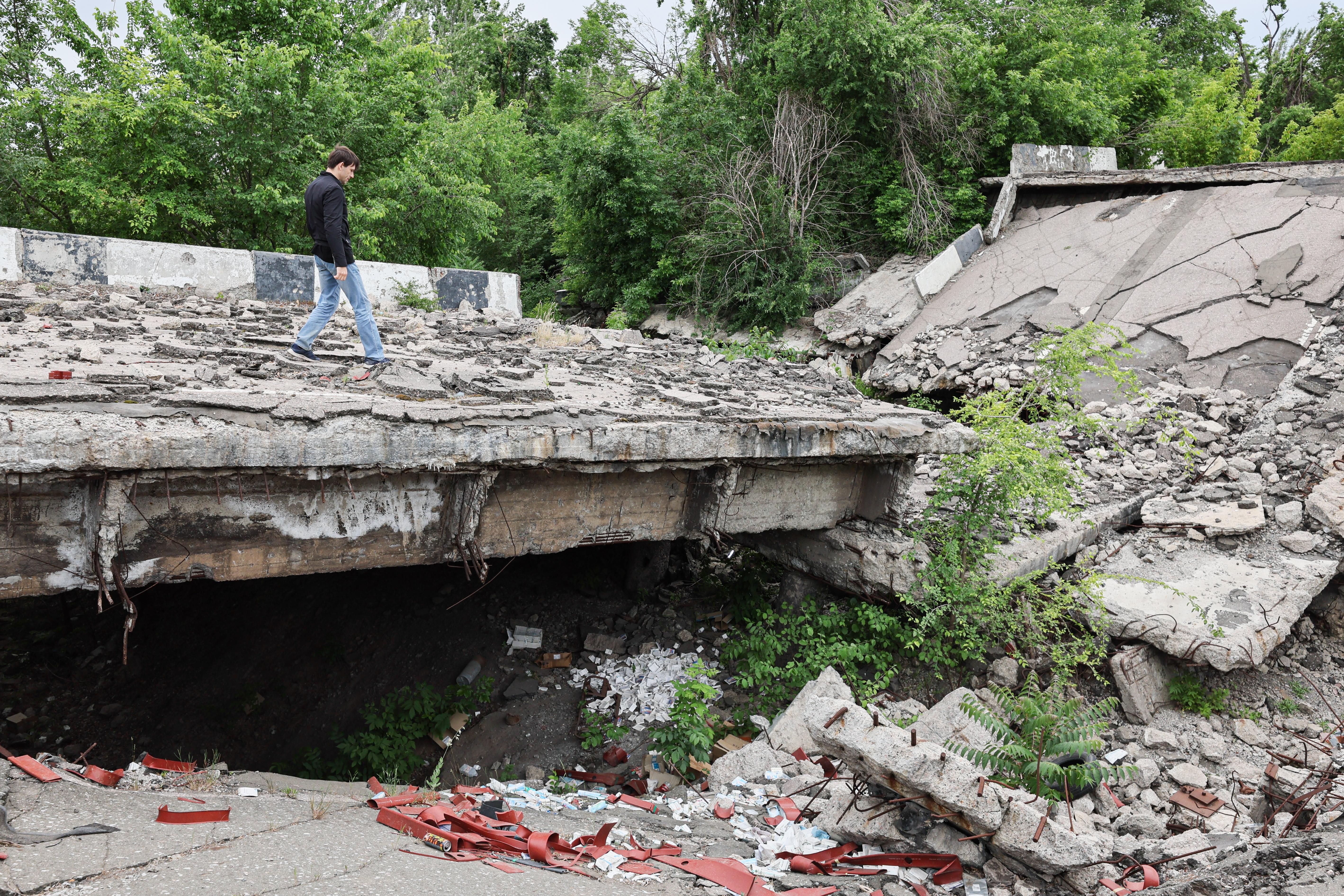 Junger Mann schreitet über Trümmer einer Betonbrücke