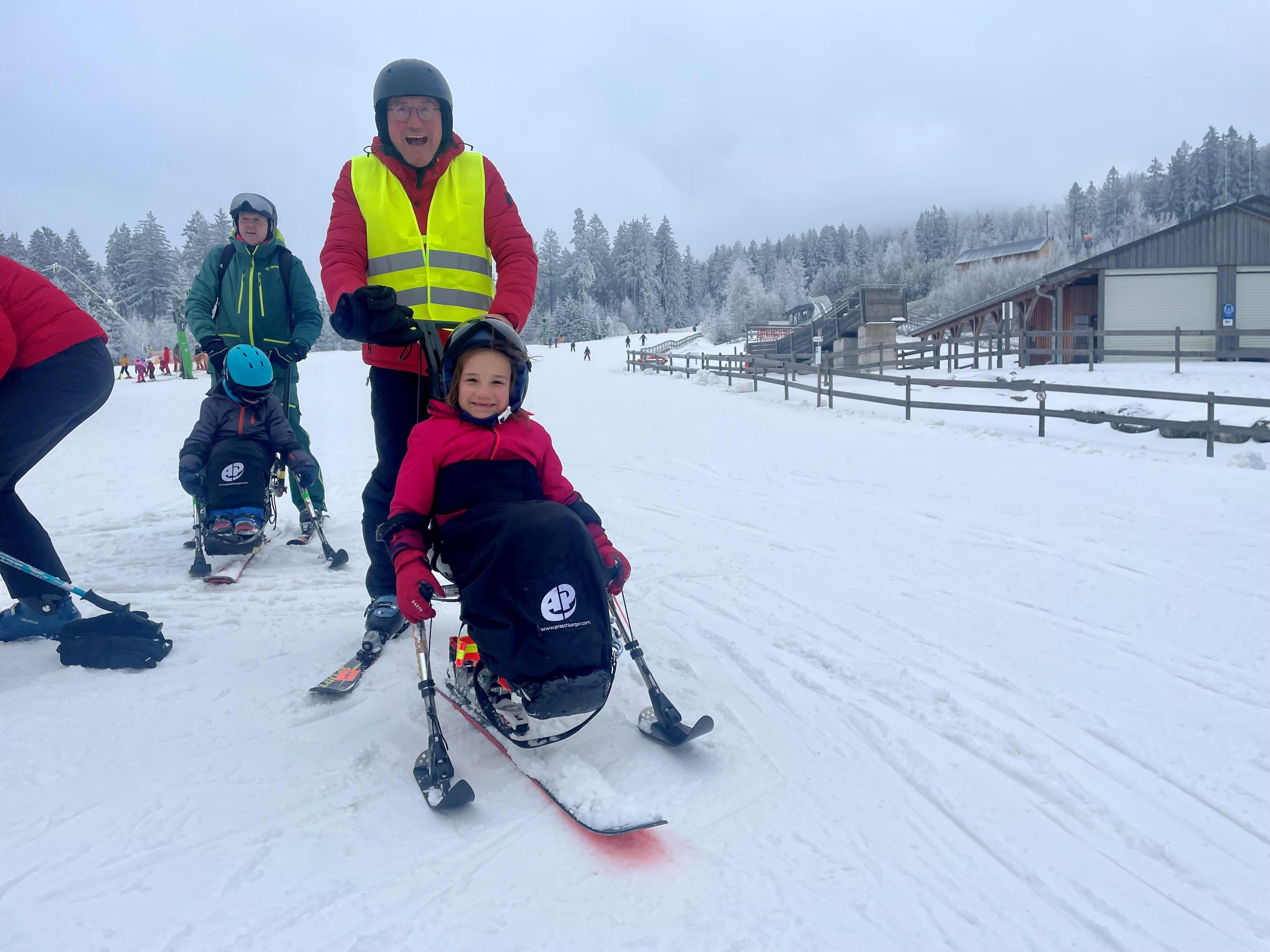 Elise im Monoski, Papa Norbert behält als Begleitperson die Übersicht.  