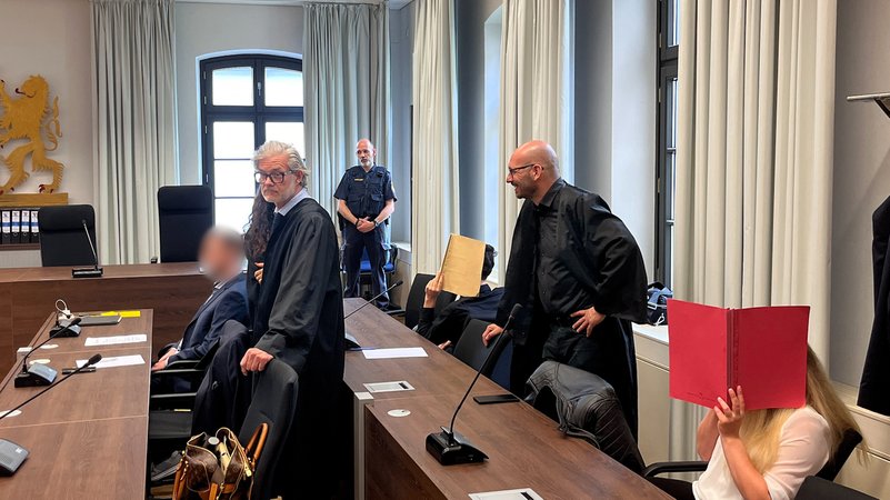 Im Gerichtssaal am Landgericht Memmingen. Die mutmaßlichen Haupttäter halten Ordner vor ihr Gesicht