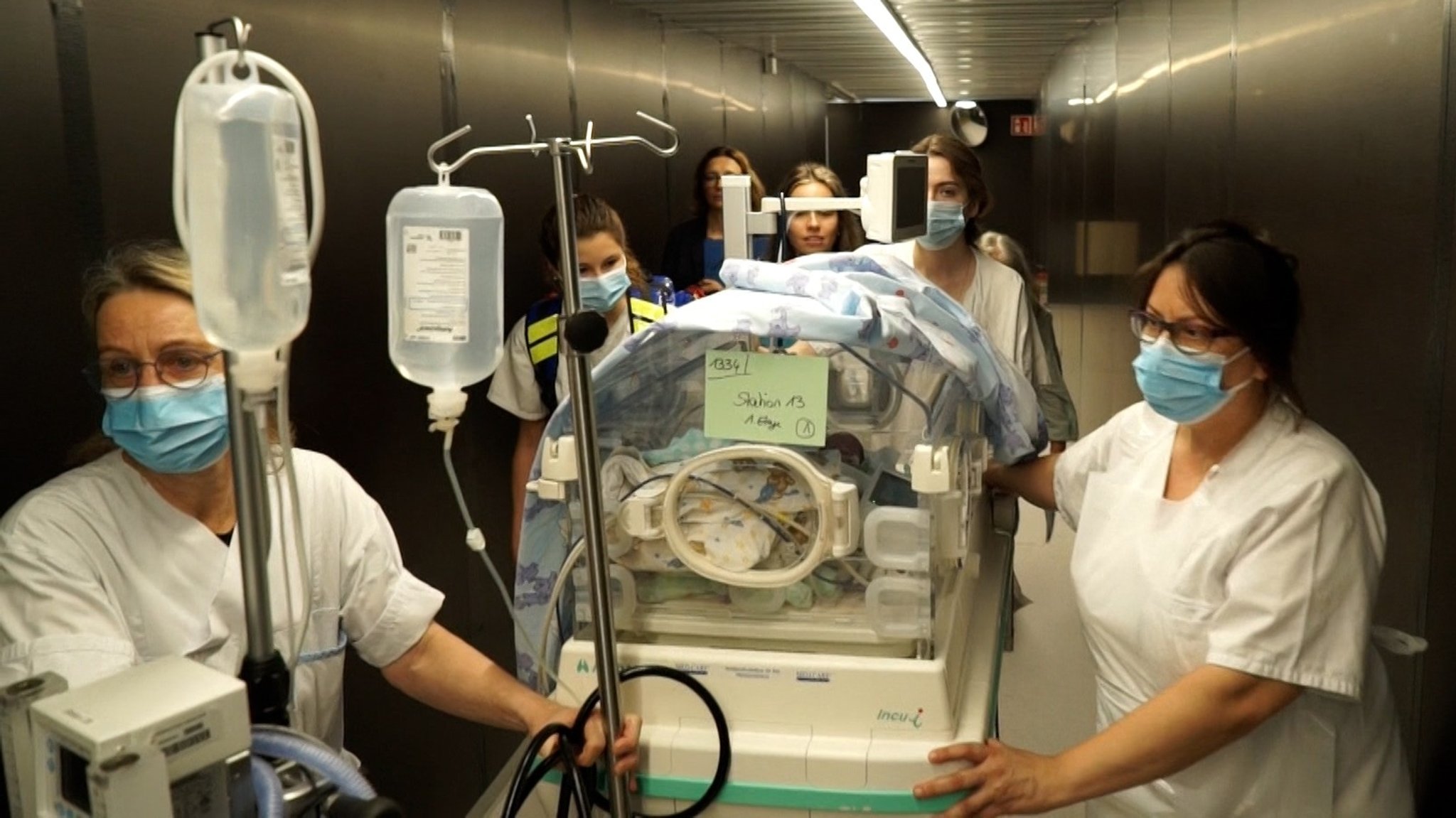 Transport eines Babys durch den Versorgungstunnel. | Bild: BR Transport eines Babys durch den Versorgungstunnel.
