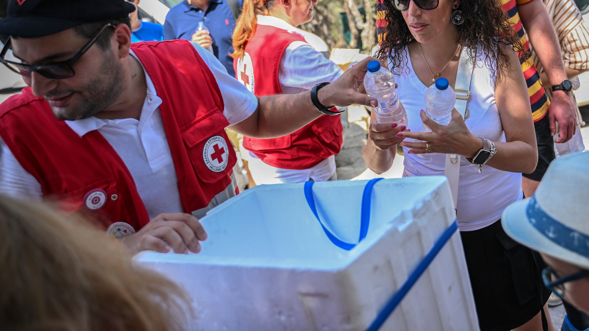 Mitarbeiter des Roten Kreuzes verteilen Wasserflaschen an Touristen (Symbolbild)