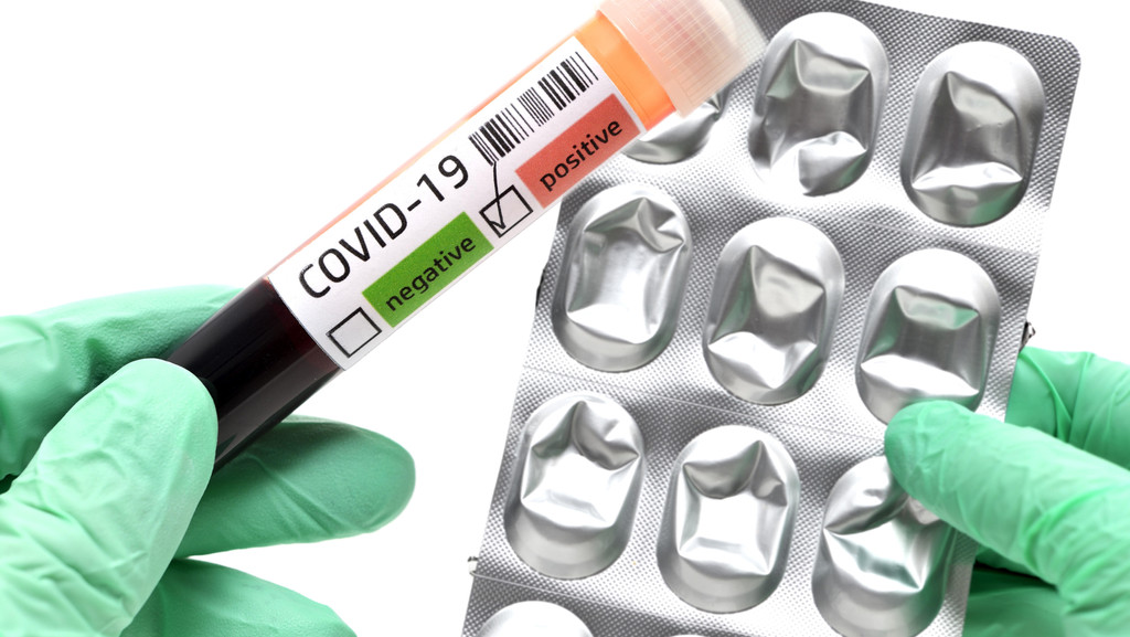 Blutprobe mit Covid-19-Infektion und eine Verpackung von Tabletten.
