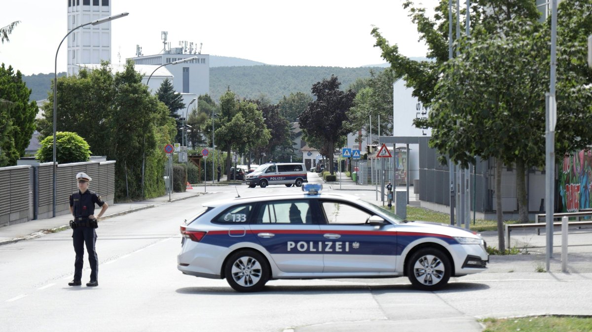 Ein Polizist und ein Polizeiwagen stehen am Einsatzort im österreichischen Ternitz, südlich von Wien.