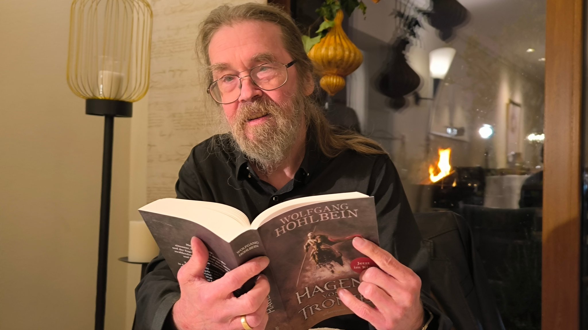 Der Schriftsteller Wolfgang Hohlbein hält sein Buch "Hagen von Tronje" in der Hand