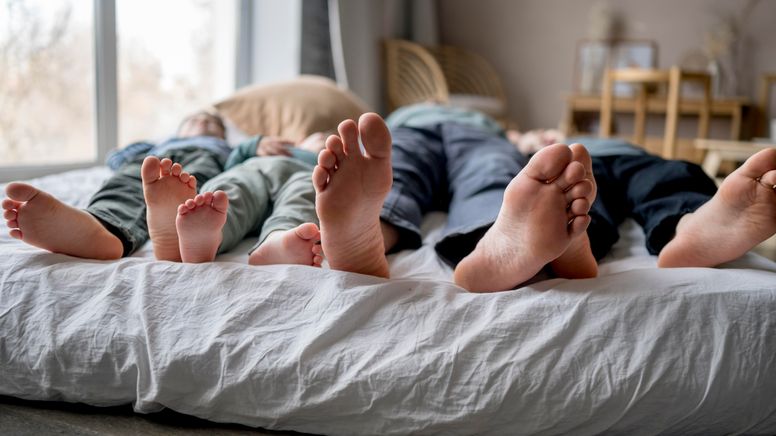 Viele Füße einer Familie in einem Bett.  | Bild:picture alliance/Westend61/Anastasiya Amraeva