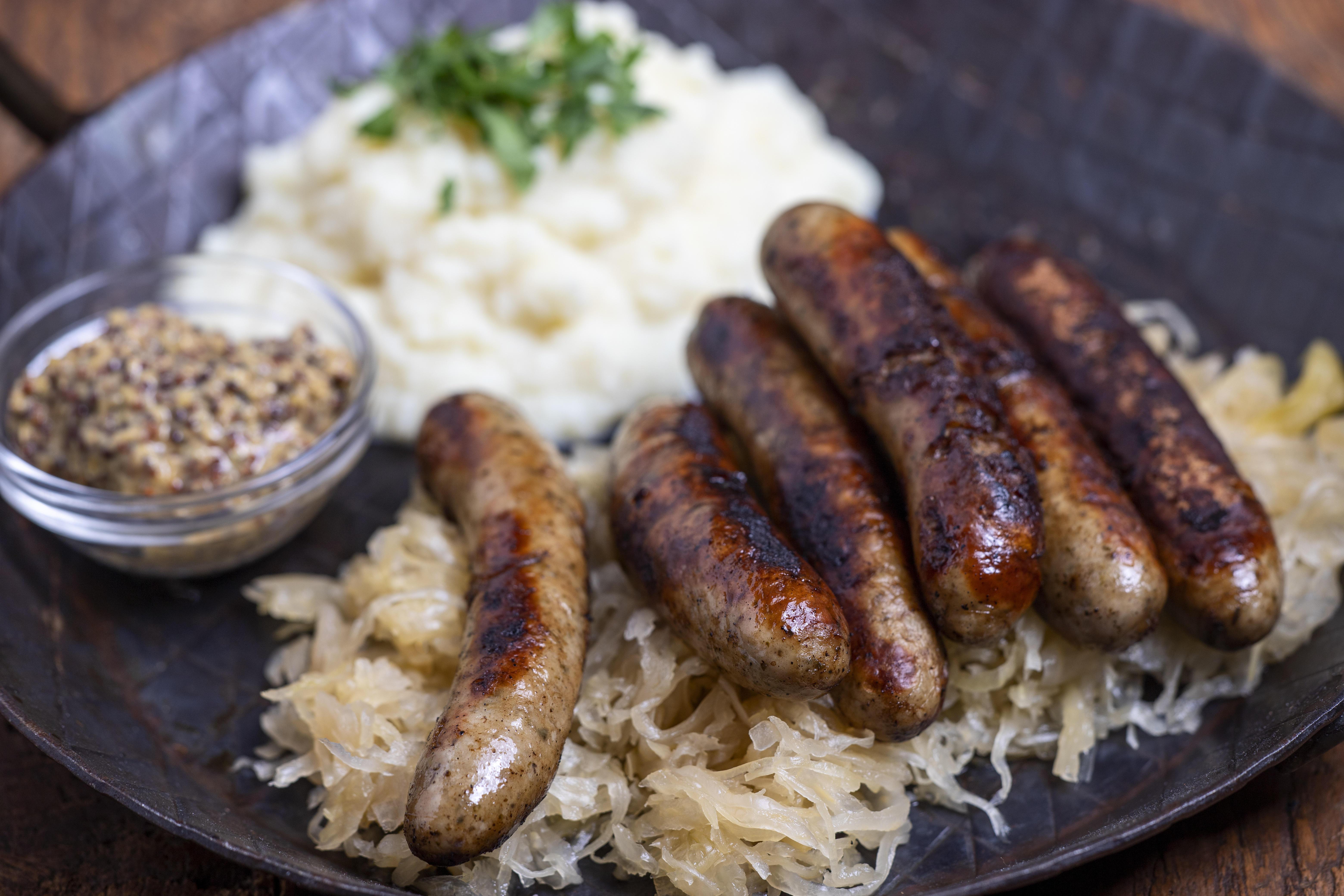 Ein Teller mit Bratwürsten auf Sauerkraut.
