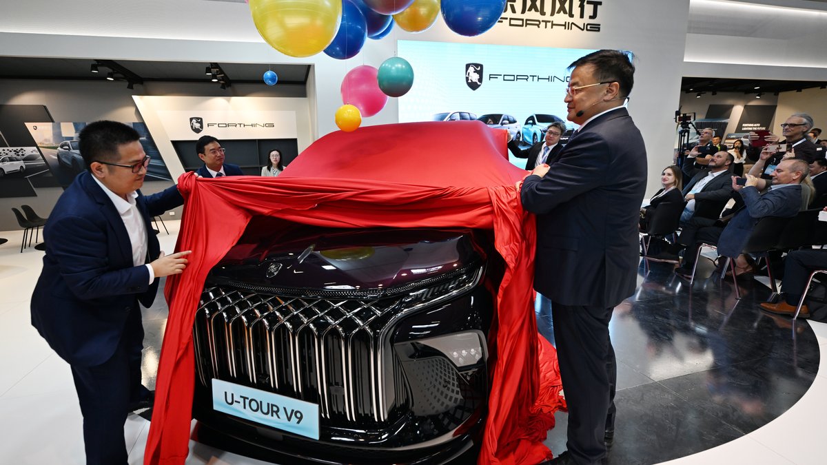 Manager der chinesischen Dongfeng Liuzhou Motor Co. Ltd. enthüllen ein neues Fahrzeug der Marke Forthing beim Pressetag IAA Mobility.