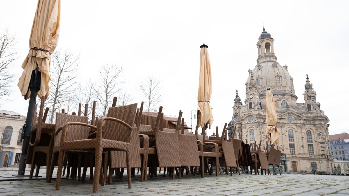 Dresden im April 2021: Leere Stühle stehen übereinander gestapelt vor einem Restaurant auf dem Neumarkt vor der Frauenkirche. 
