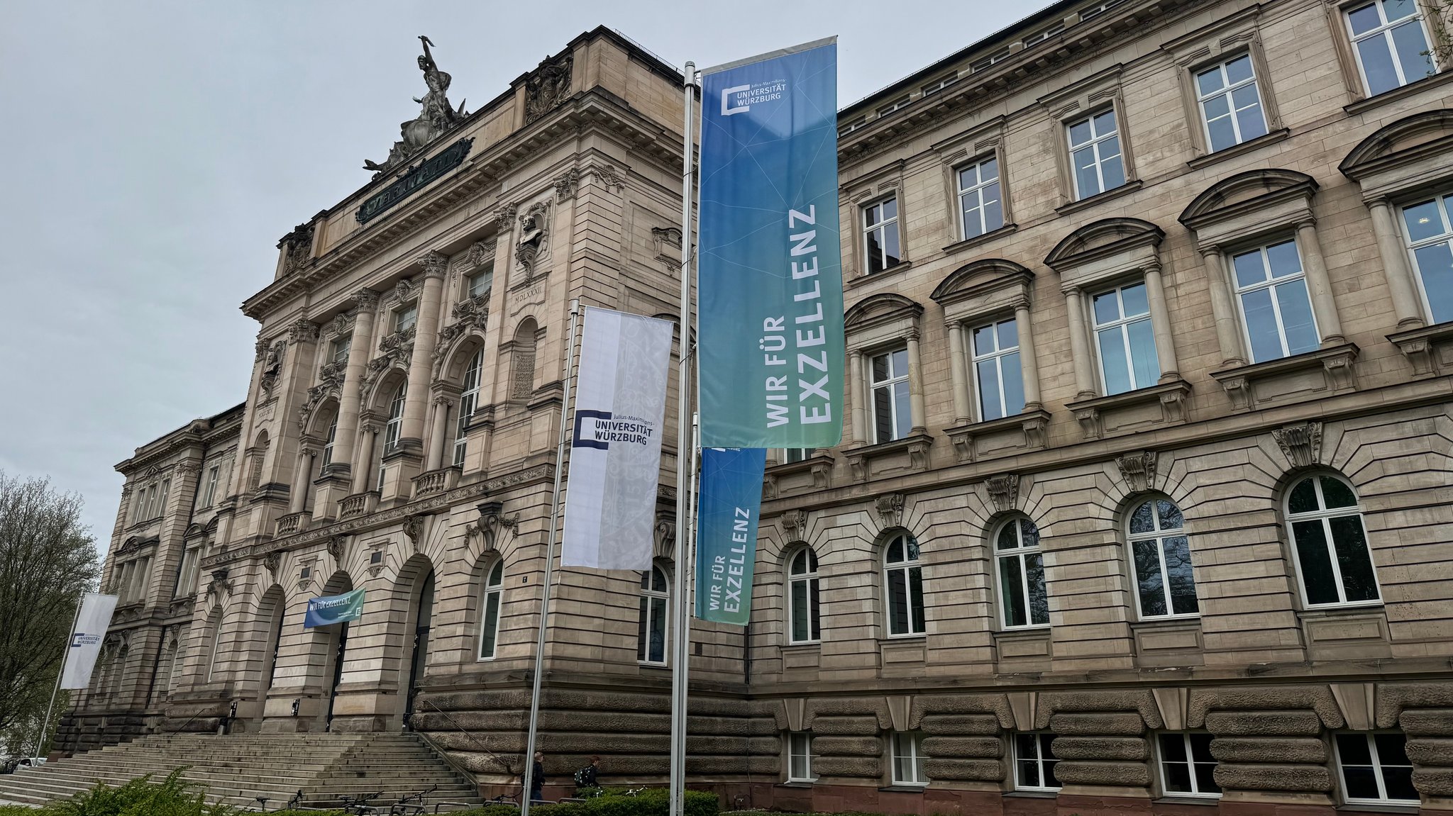 Gebäude der Universität Würzburg mit Fahnen "Wir für Exzellenz"