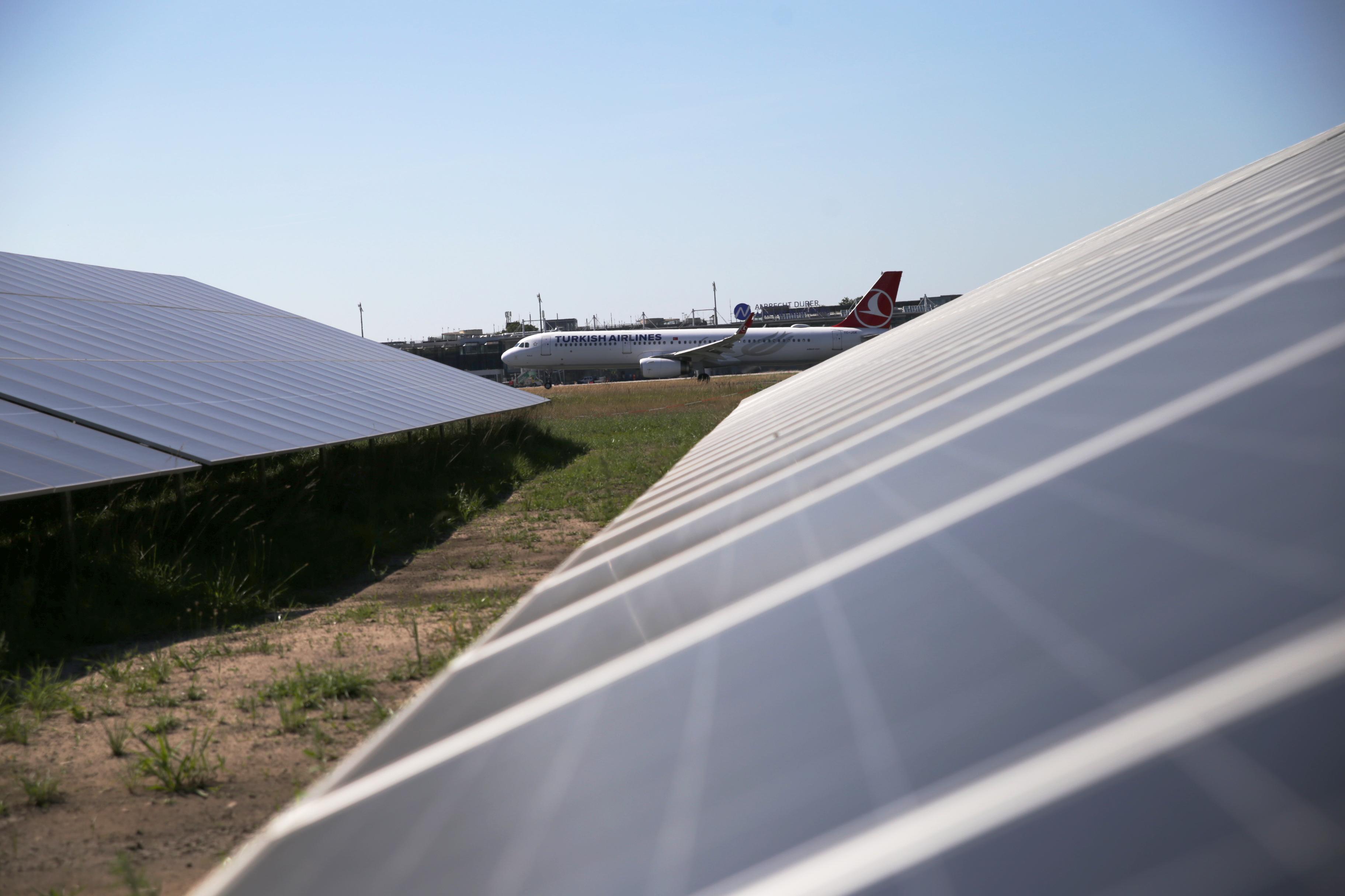 Ein Flugzeug am Flughafen Nürnberg, im Vordergrund eine PV-Anlage