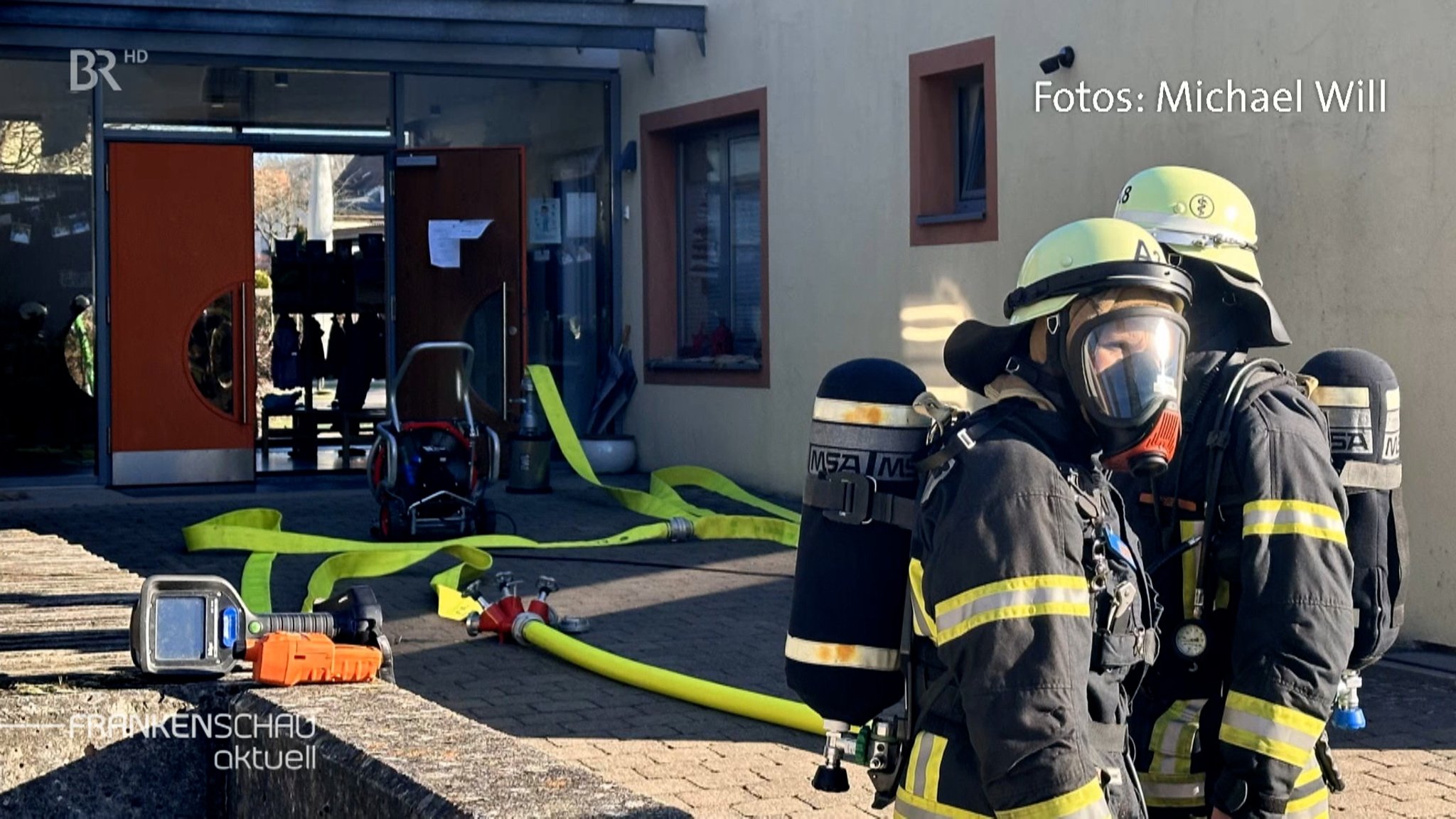 ZWei Feuerwehrleute vor dem Kindergarten