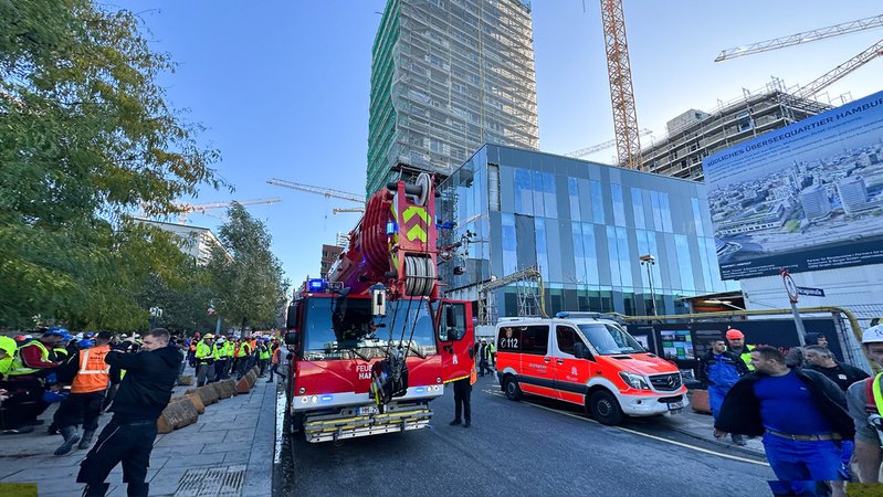 Rettungskräfte und Bauarbeiter stehen am Ort des tödlichen Unfalls in Hamburg